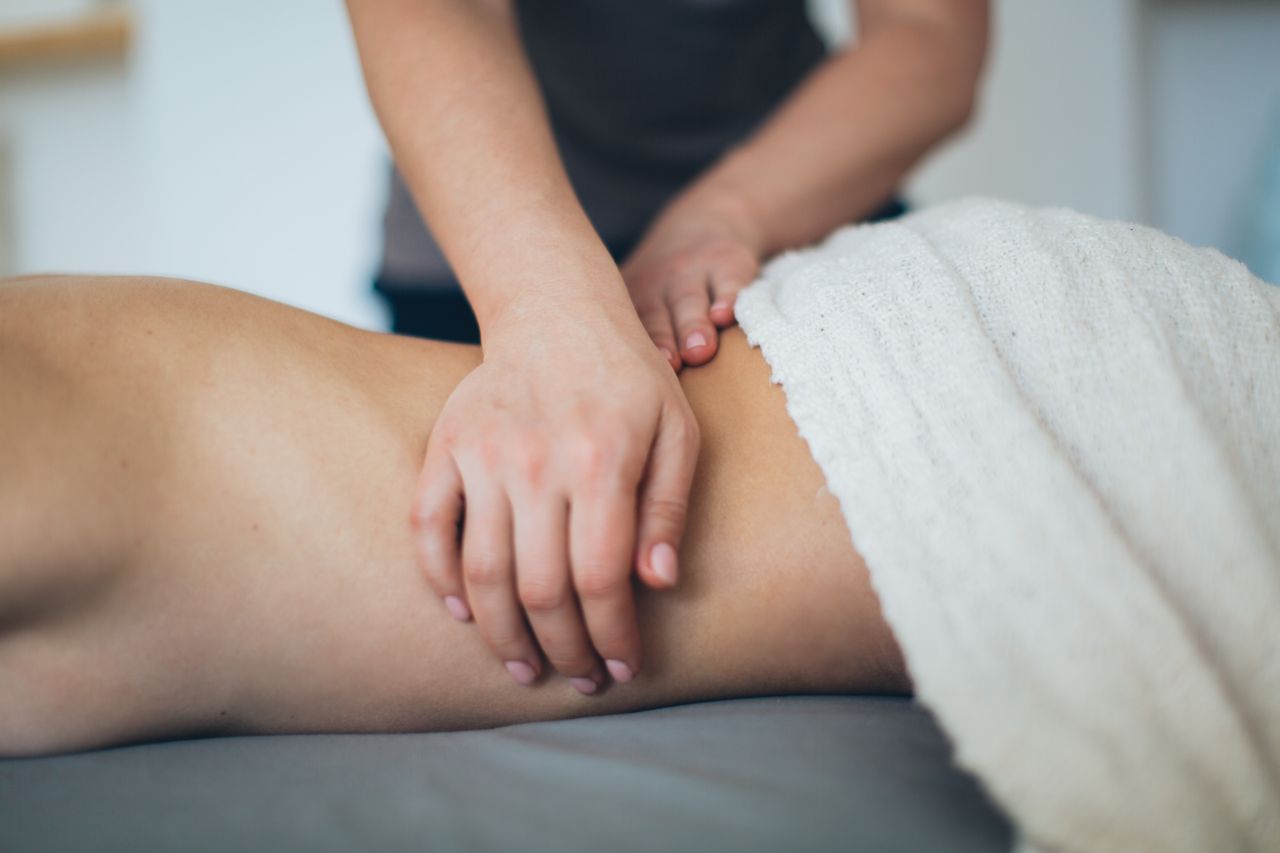 Home Close-up of a woman receiving a therapeutic massage in a serene spa setting with a white towel.